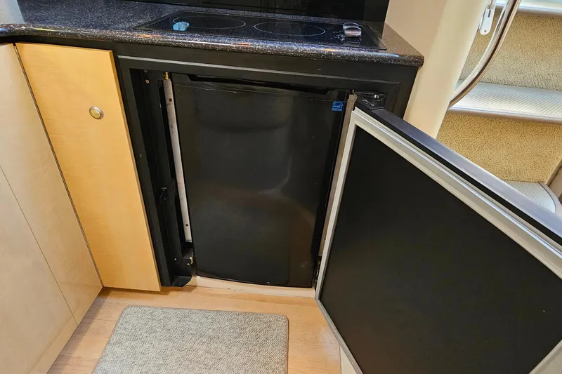 Slide: The Image of 2001 Maxum 3500 SCR yacht interior with open refrigerator and compact kitchen area. - 28