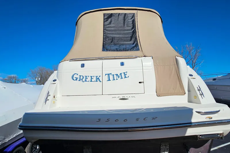 Slide: The Image of 2001 Maxum 3500 SCR boat named "Greek Time" with beige canopy under clear blue sky. - 4
