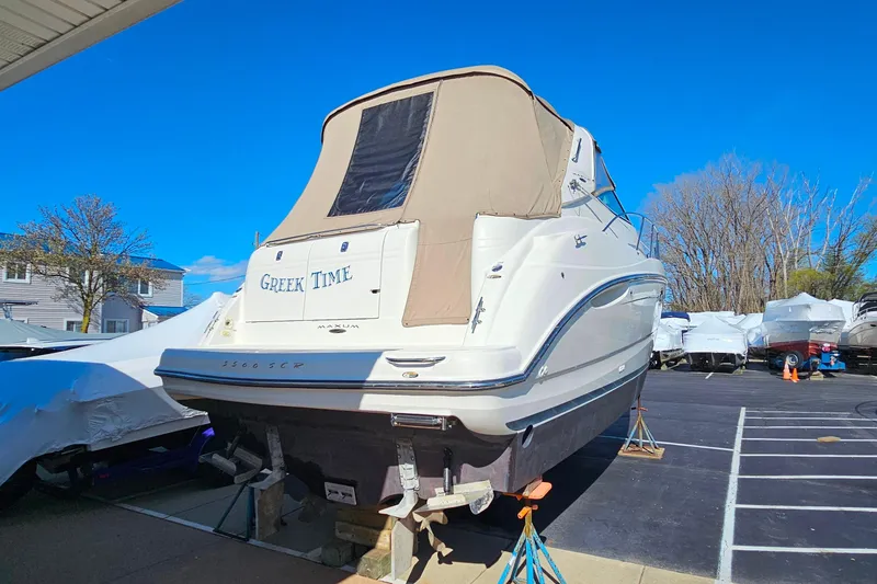 Slide: The Image of 2001 Maxum 3500 SCR boat named "Greek Time" on dry dock under clear blue sky. - 5