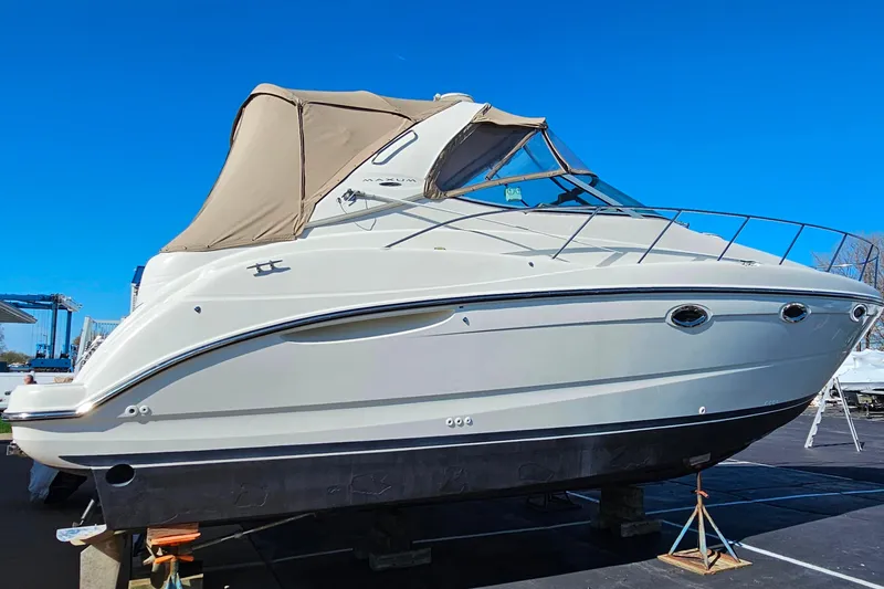 Slide: The Image of 2001 Maxum 3500 SCR boat with beige canopy, displayed on stands under clear blue sky. - 6