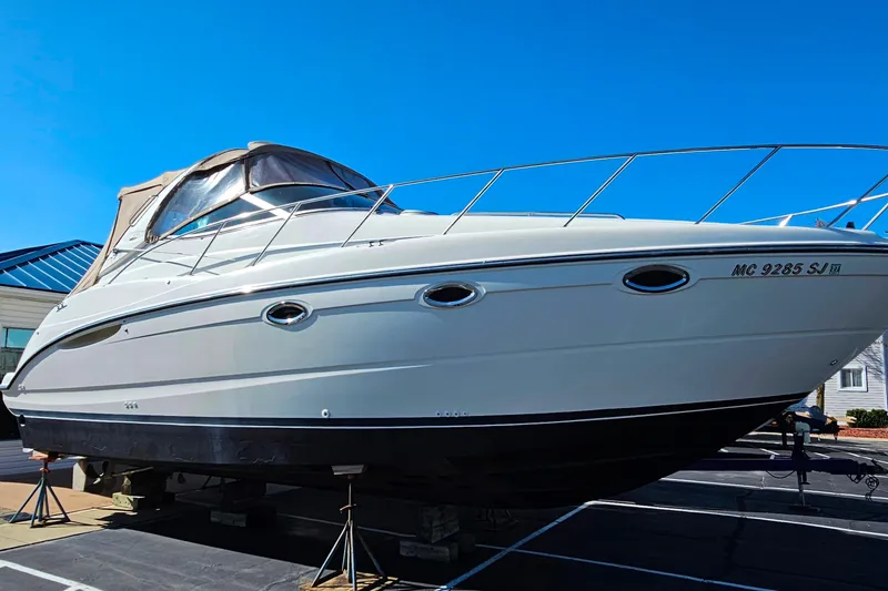 Slide: The Image of 2001 Maxum 3500 SCR boat on stands, displayed outdoors under clear blue sky. - 7