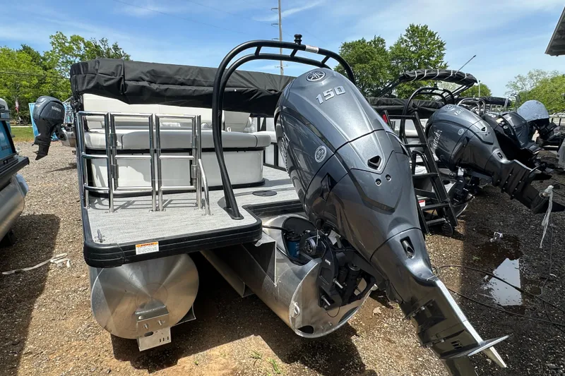 Slide: The Image of 2026 Godfrey Sweetwater 2286 SFLC pontoon boat with Yamaha 150 engine, parked outdoors. - 4