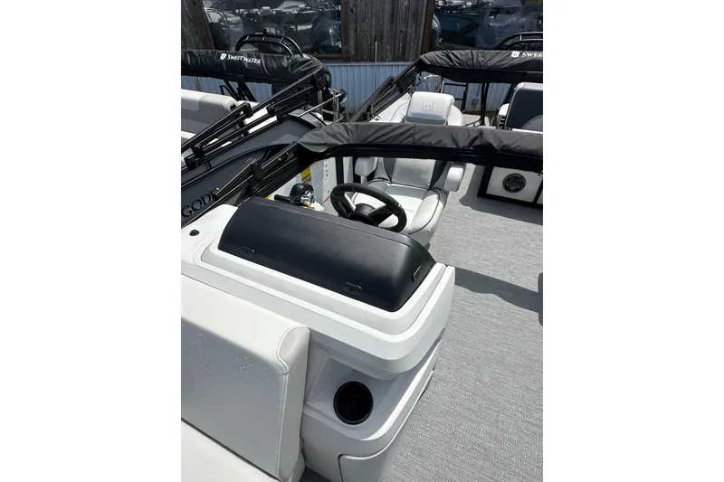 Slide: The Image of 2026 Godfrey Sweetwater 2286 SFLC boat interior with steering wheel and seating. - 9