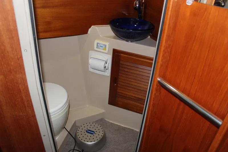 Slide: The Image of 2011 Ranger Tugs R-27 boat bathroom with wooden accents and blue sink. - 10