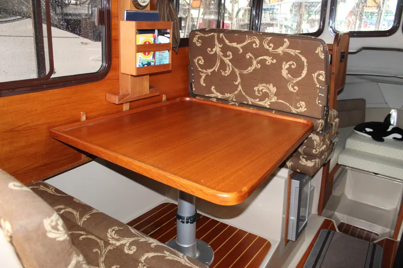 Slide: The Image of Interior of 2011 Ranger Tugs R-27 with wooden table and patterned seating. - 14