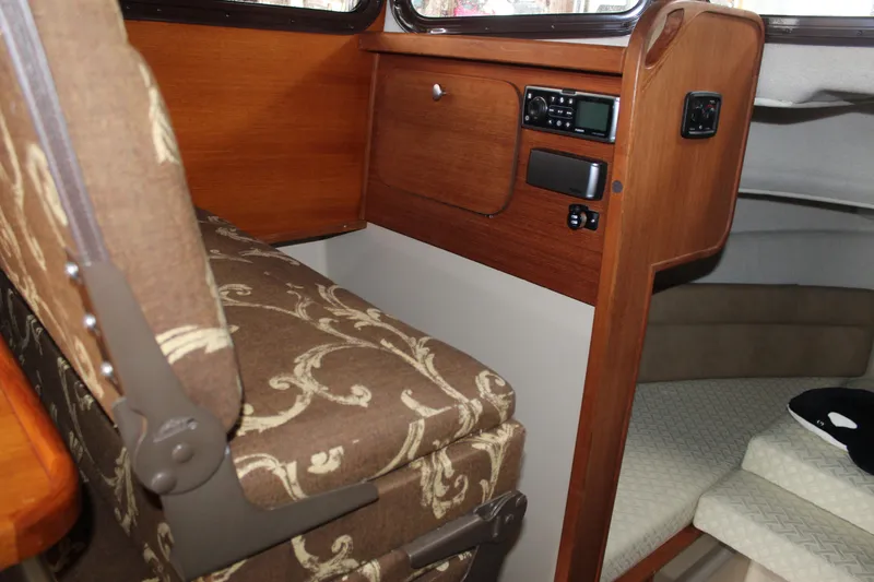 Slide: The Image of Interior of 2011 Ranger Tugs R-27 boat with patterned seating and wooden cabinetry. - 16