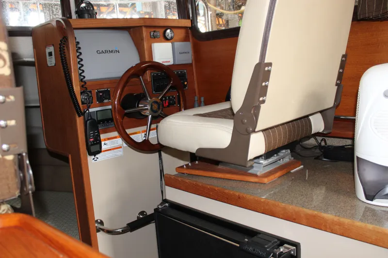 Slide: The Image of Interior helm of 2011 Ranger Tugs R-27 with Garmin navigation system and captain's chair. - 18