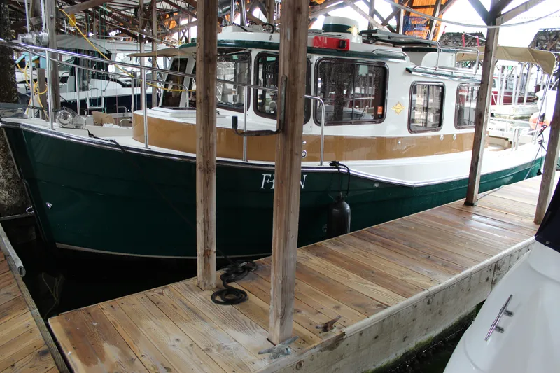 Slide: The Image of 2011 Ranger Tugs R-27 docked in a covered marina. - 2