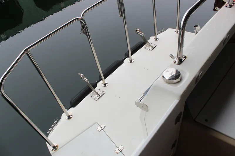 Slide: The Image of 2011 Ranger Tugs R-27 boat deck with stainless steel railings and calm water reflection. - 20