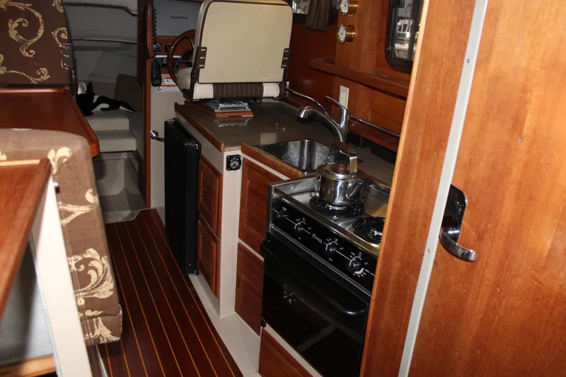 Slide: The Image of Interior of 2011 Ranger Tugs R-27 boat featuring kitchen with stove and sink. - 25