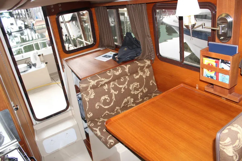 Slide: The Image of Interior of 2011 Ranger Tugs R-27 with wood table and patterned seating. - 35