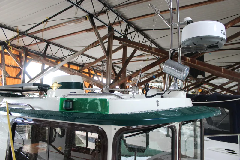 Slide: The Image of 2011 Ranger Tugs R-27 boat under covered dock with radar equipment. - 5