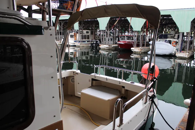 Slide: The Image of 2011 Ranger Tugs R-27 docked in a marina with covered slips. - 8
