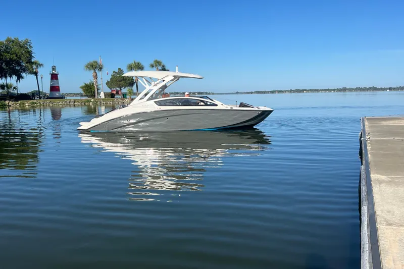 Slide: The Image of 2022 Yamaha 275 SD boat on calm water near a lighthouse and palm trees. - 3