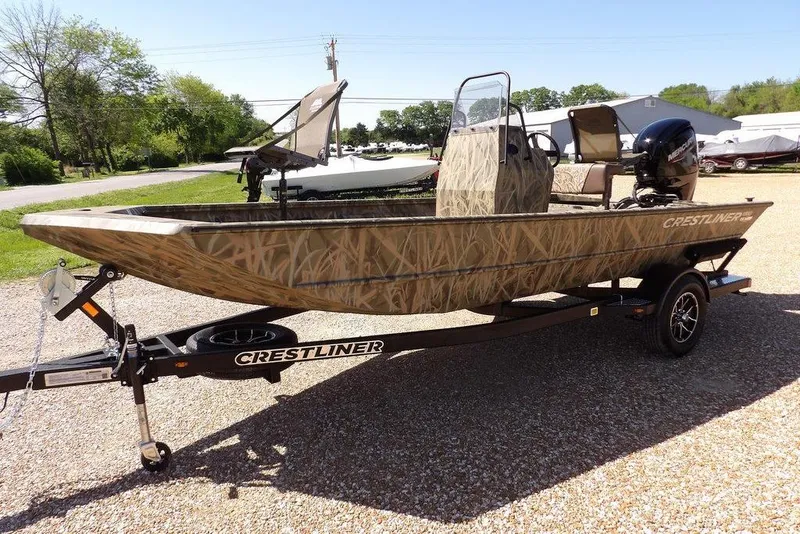 Slide: The Image of 2026 Crestliner 1860 Retriever CC boat on trailer, camo design, parked outdoors. - 9