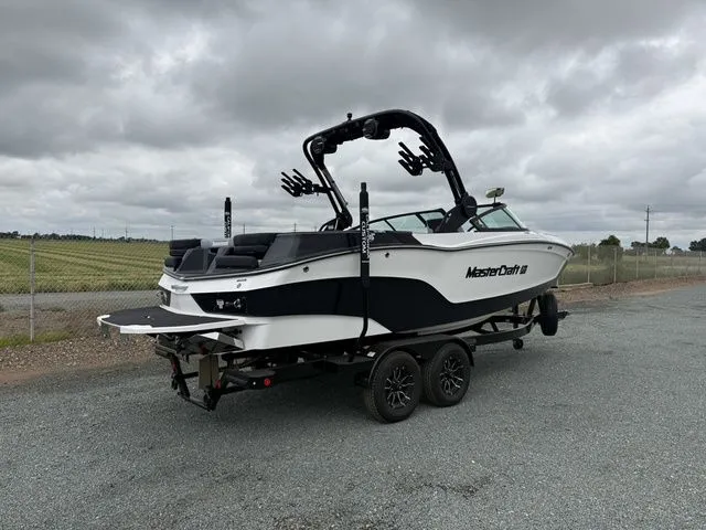 Slide: The Image of 2026 MasterCraft XT22 boat on trailer, cloudy sky. - 3