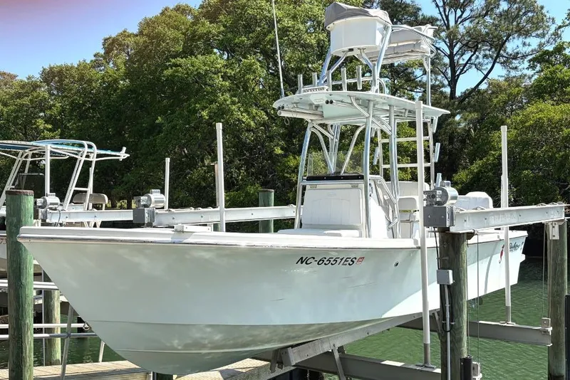 The Image of 2021 Pair Customs 24 Center Console MV boat docked, surrounded by lush greenery. - 0