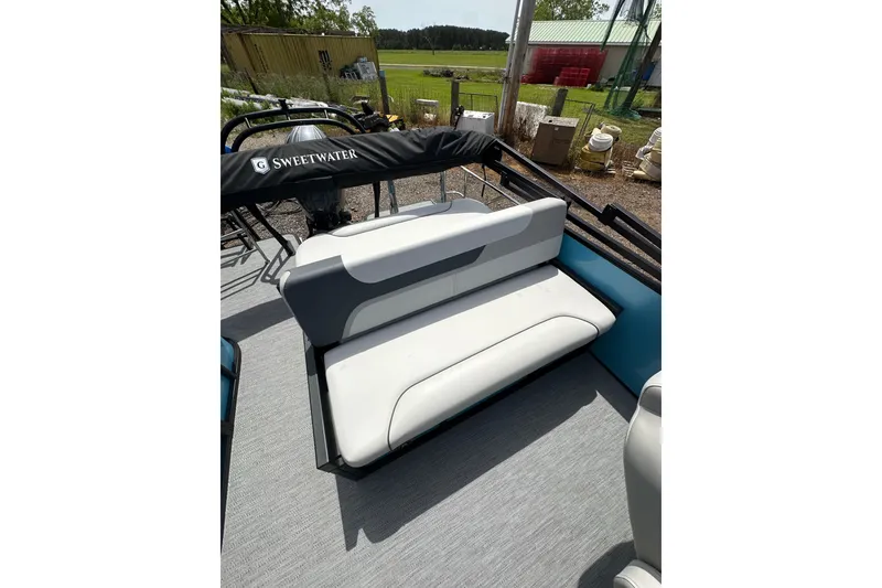 Slide: The Image of 2026 Godfrey Sweetwater 2286 SFLC boat with cushioned seating and outdoor backdrop. - 18