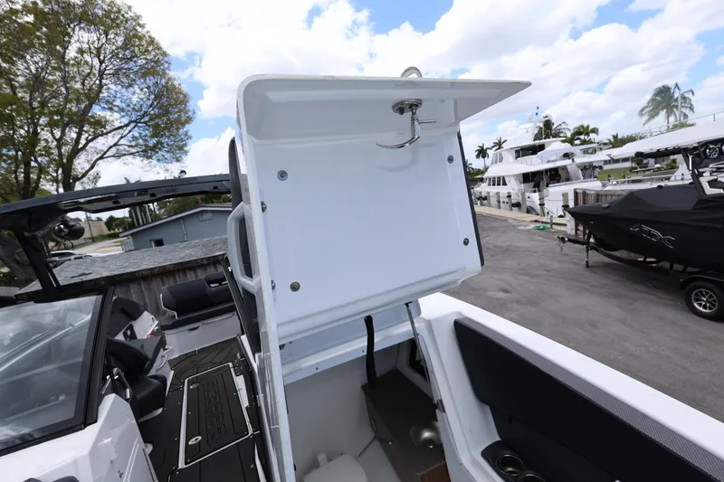 Slide: The Image of 2024 Scarab 285 ID boat interior with open storage compartment at marina. - 17