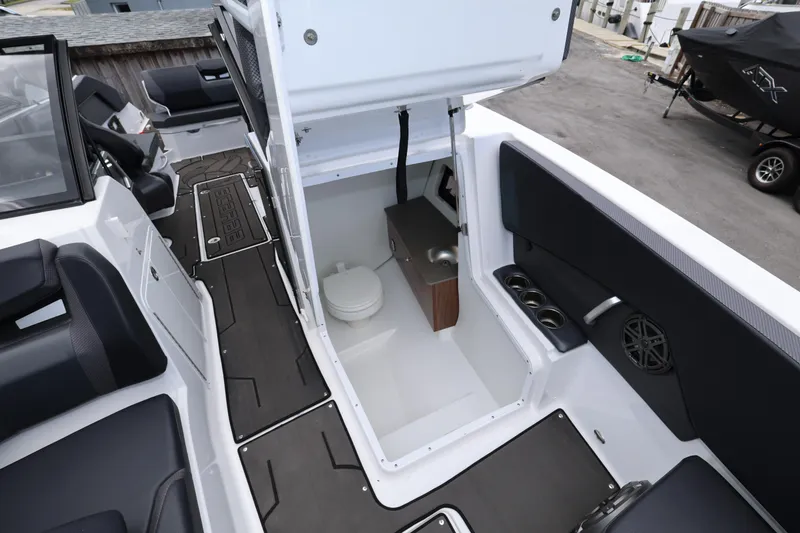Slide: The Image of 2024 Scarab 285 ID boat interior with open hatch revealing compact bathroom. - 18