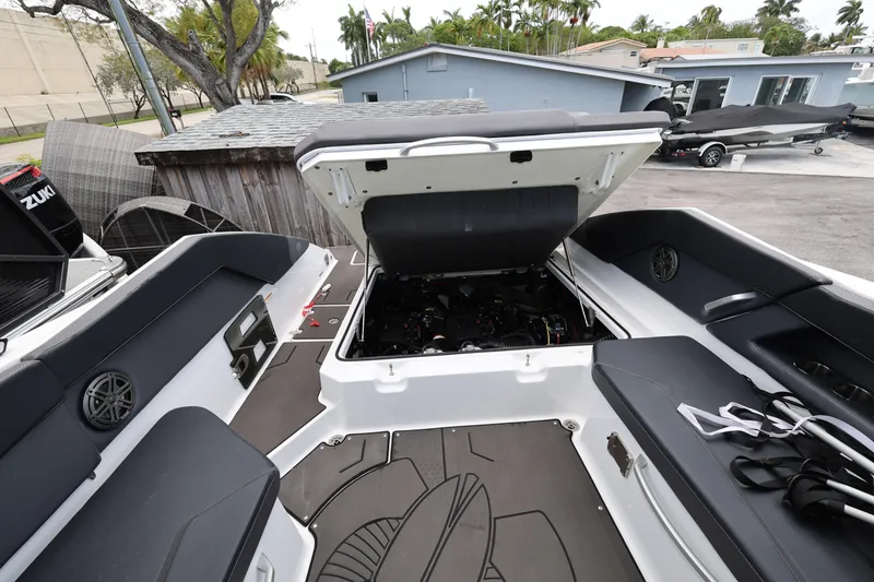 Slide: The Image of 2024 Scarab 285 ID boat interior with open engine compartment, showcasing seating and deck layout. - 21