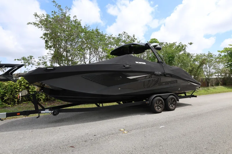 Slide: The Image of 2024 Scarab 285 ID boat on trailer, covered, parked on roadside. - 3
