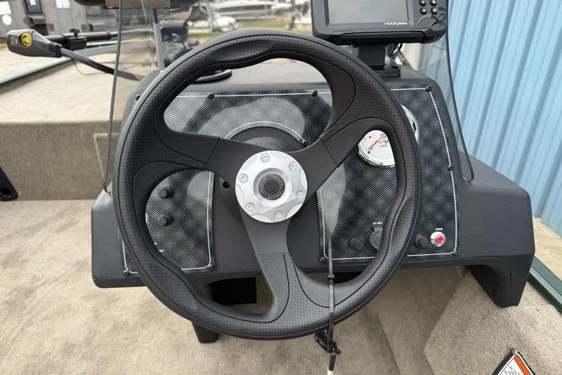 Slide: The Image of Steering wheel of 2026 Tracker Bass Tracker Classic Limited boat with dashboard controls. - 12