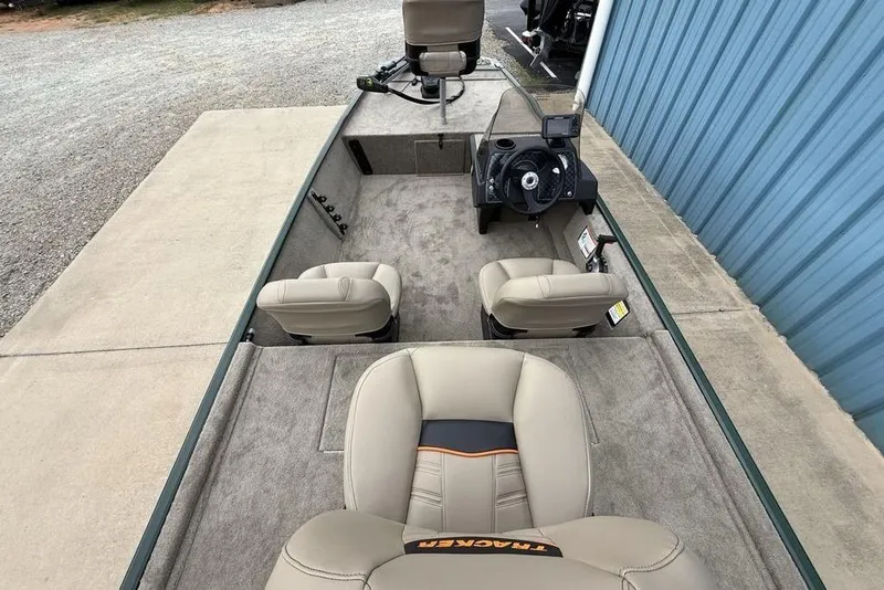 Slide: The Image of 2026 Tracker Bass Tracker Classic Limited boat interior with beige seating and steering console. - 13