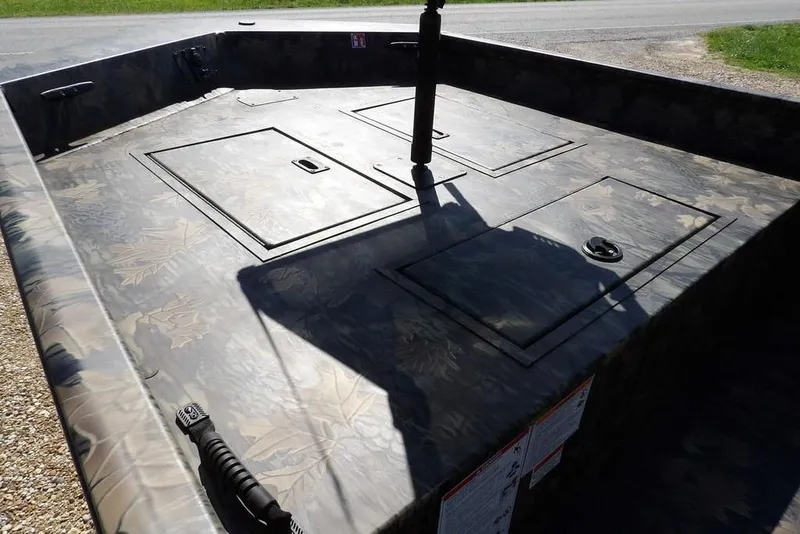 Slide: The Image of 2026 Crestliner 1860 Retriever CC Tunnel boat deck with camouflage pattern and storage compartments. - 13