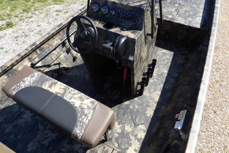 Slide: The Image of 2026 Crestliner 1860 Retriever CC Tunnel boat interior with camouflage design and steering console. - 14