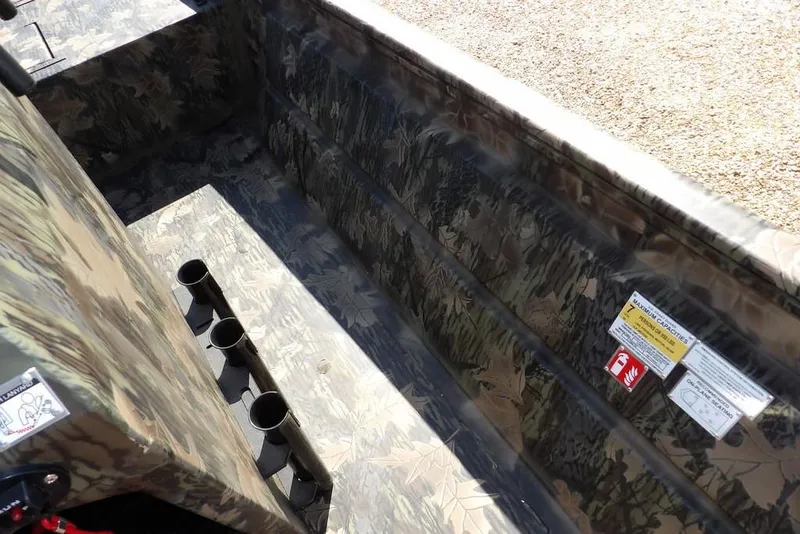 Slide: The Image of Crestliner 1860 Retriever CC Tunnel 2026 interior with camouflage design and rod holders. - 17