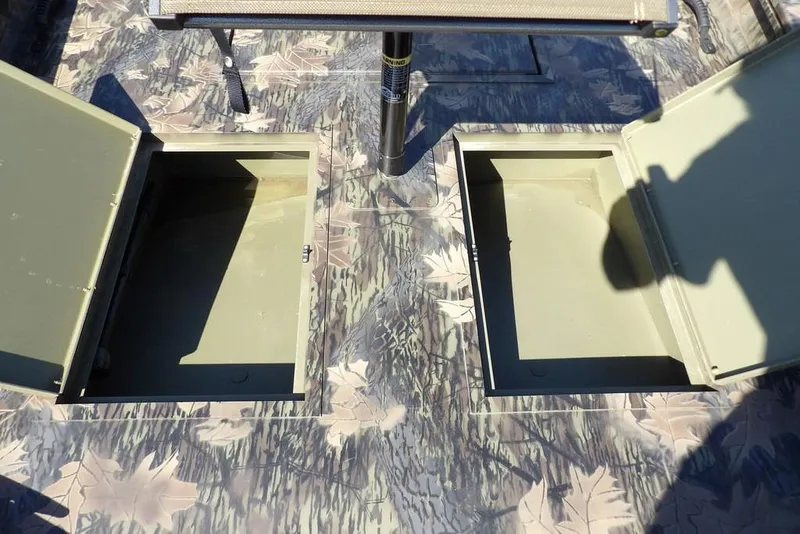 Slide: The Image of Crestliner 1860 Retriever CC Tunnel 2026 boat with open storage compartments on camo deck. - 21