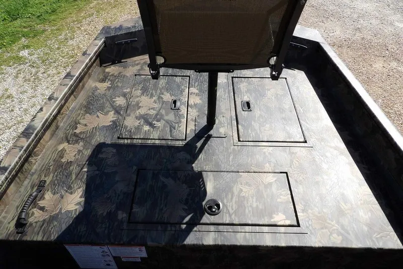 Slide: The Image of 2026 Crestliner 1860 Retriever CC Tunnel boat deck with camouflage pattern and storage compartments. - 23