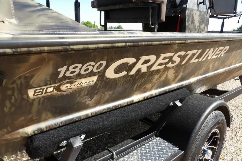 Slide: The Image of 2026 Crestliner 1860 Retriever CC Tunnel boat with camouflage design on trailer. - 26