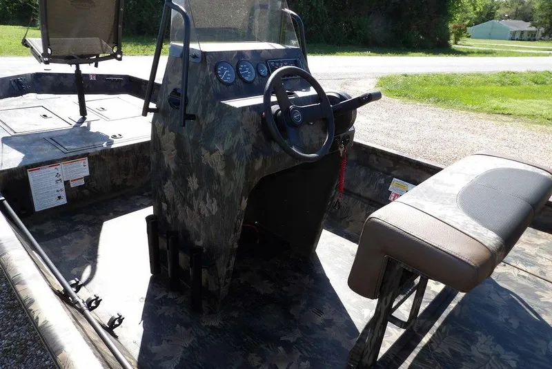 Slide: The Image of 2026 Crestliner 1860 Retriever CC Tunnel boat interior with camouflage design and steering console. - 29