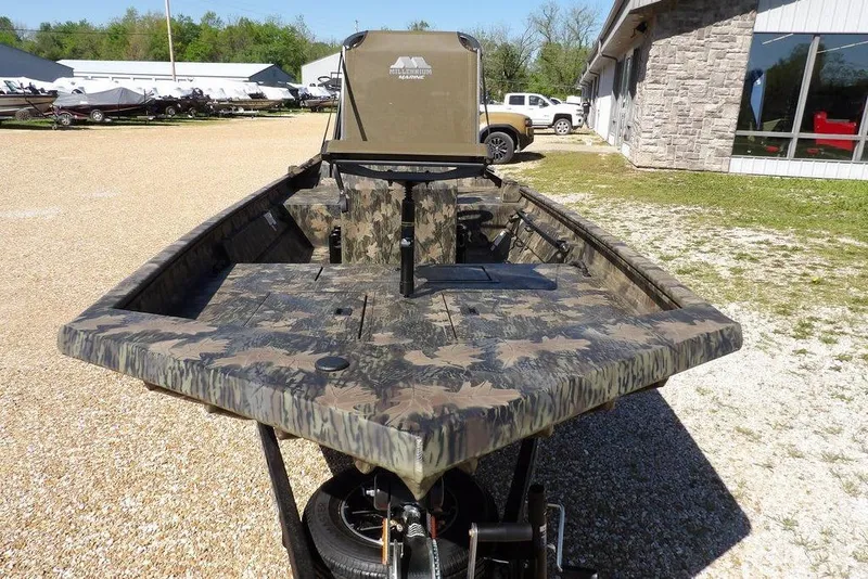 Slide: The Image of 2026 Crestliner 1860 Retriever CC Tunnel boat with camouflage design on display outdoors. - 3