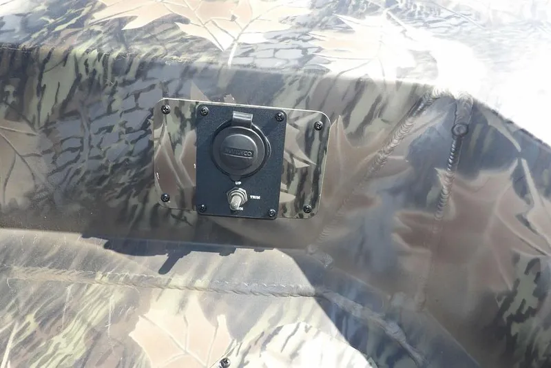 Slide: The Image of 2026 Crestliner 1860 Retriever CC Tunnel boat with camouflage pattern and control panel. - 34