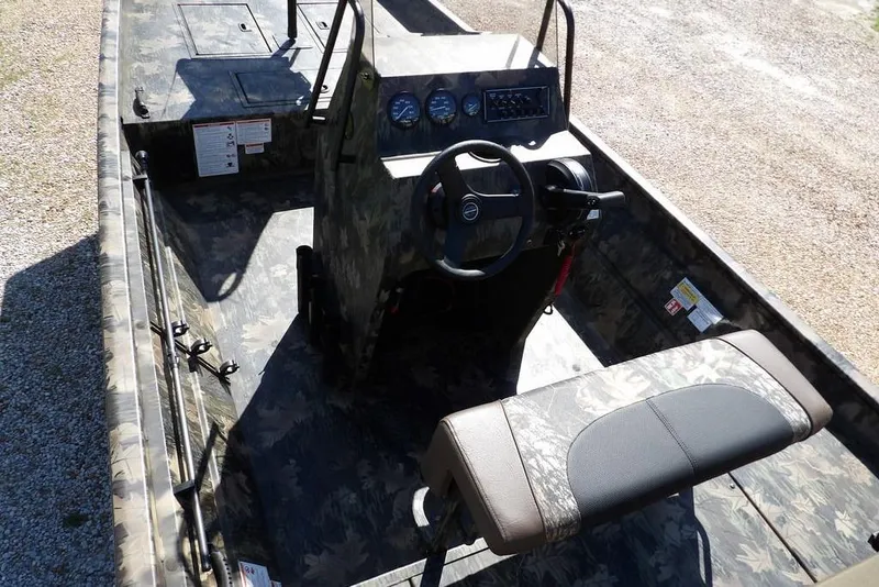 Slide: The Image of 2026 Crestliner 1860 Retriever CC Tunnel boat interior with camouflage design and steering console. - 9