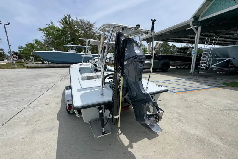 Slide: The Image of 2016 Hell's Bay Professional boat with outboard motor on a trailer in a marina. - 13