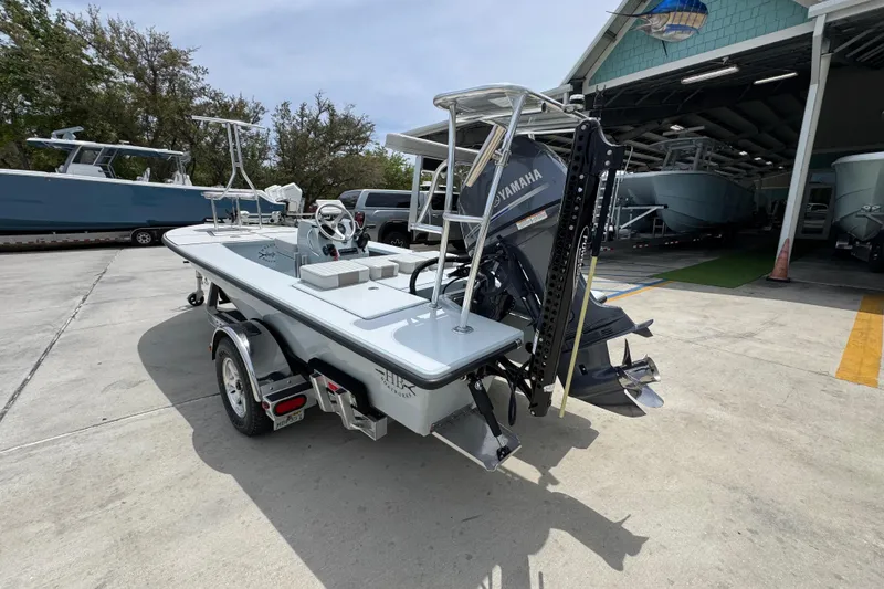 Slide: The Image of 2016 Hell's Bay Professional boat with Yamaha engine on trailer, parked outside a marina. - 14