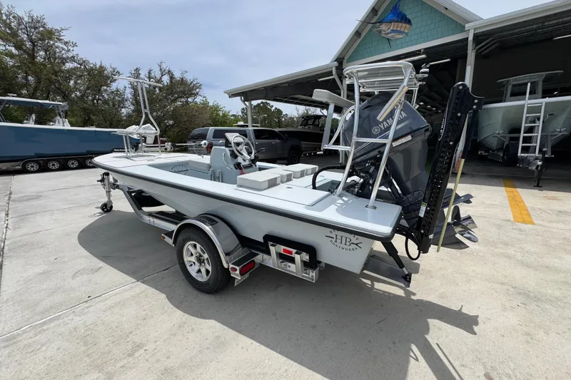 Slide: The Image of 2016 Hell's Bay Professional boat on trailer, parked outside a boat workshop. - 15