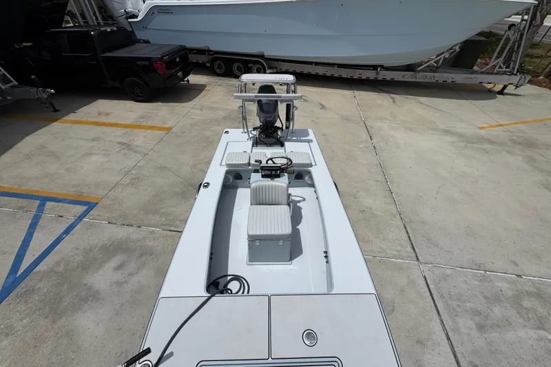 Slide: The Image of 2016 Hell's Bay Professional boat parked on concrete, showcasing sleek design and seating arrangement. - 23