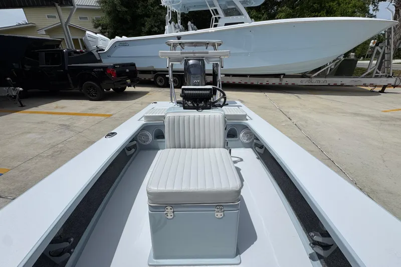 Slide: The Image of 2016 Hell's Bay Professional boat interior with seating and motor, parked outdoors. - 24