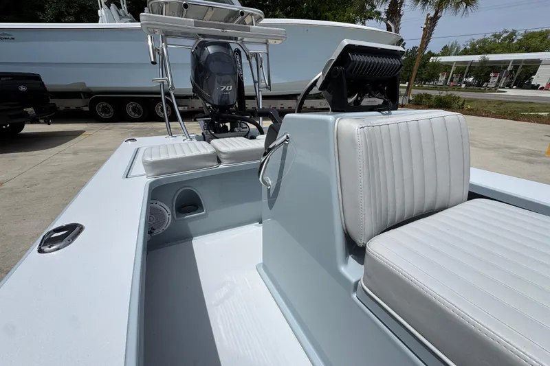 Slide: The Image of 2016 Hell's Bay Professional boat interior with seating and motor, parked outdoors. - 26