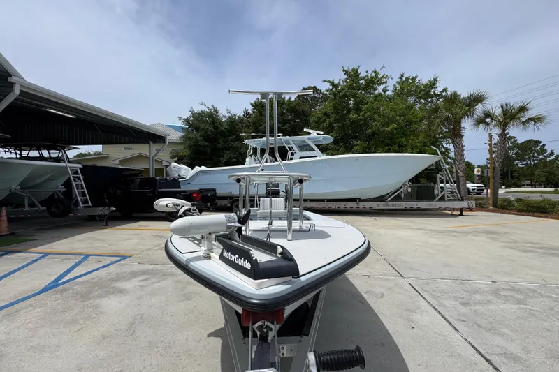 Slide: The Image of 2016 Hell's Bay Professional boat with MotorGuide, parked outdoors near other boats. - 5