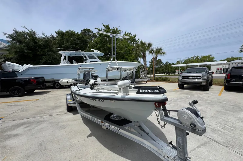 Slide: The Image of 2016 Hell's Bay Professional boat on trailer in parking lot, surrounded by vehicles. - 6
