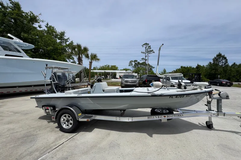 Slide: The Image of 2016 Hell's Bay Professional boat on trailer, parked outdoors with trees and vehicles in background. - 8