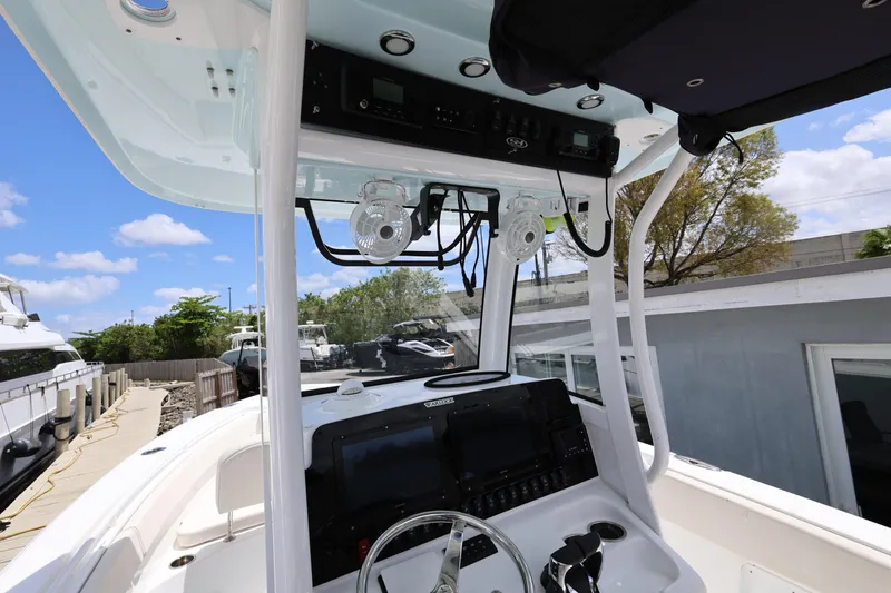 Slide: The Image of 2024 Sea Hunt Gamefish 25 boat cockpit with modern controls and overhead electronics. - 11