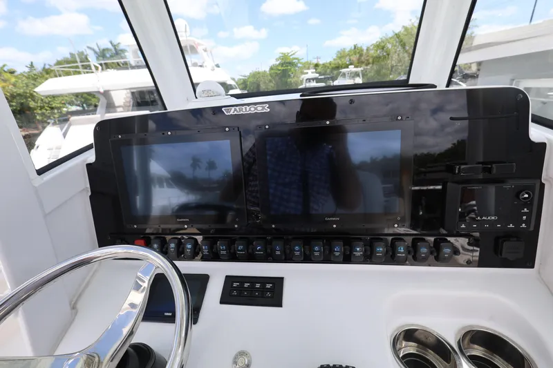 Slide: The Image of 2024 Sea Hunt Gamefish 25 dashboard with dual Garmin displays and JL Audio system. - 14