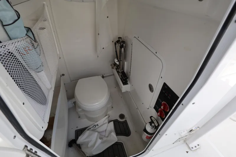 Slide: The Image of 2024 Sea Hunt Gamefish 25 boat interior with toilet and storage area. - 20